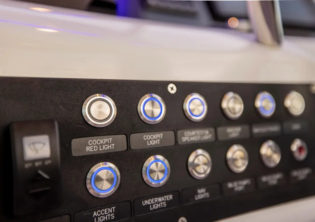 Close-up of a control panel featuring buttons for cockpit, underwater, and accent lights, with labels and illuminated rings.